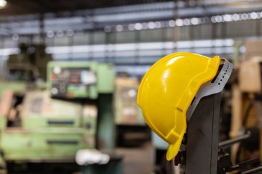 Sanayi fabrikasında kafa güvenliği için sarı başlık ya da sert şapka. İşçi inşaatı için güvenli ekipman. Gelecekçi sanayi üretimi.