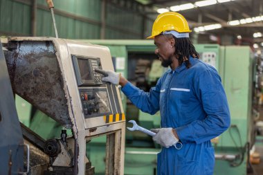 Erkek Afrikalı Amerikalı işçiler, fabrika makinelerini tamir etmek için ingiliz anahtarı takıyorlar. erkek bakım fabrikası, mekanik tamirci konsepti.