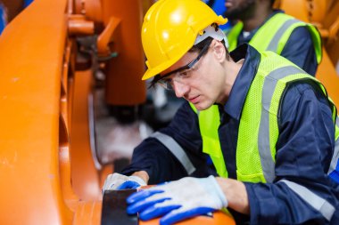 Erkek teknisyen, endüstriyel modern fabrikada otomasyon robotik kolunu kontrol ediyor. Fabrika yenileme otomasyon robotunda çalışan adam..