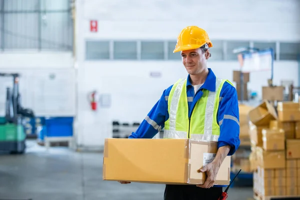 安全制服とハード帽子の労働者のチェックリストボックスを身に着けている人プロの労働者は 倉庫内の棚の製品を検査する 男性労働者貯蔵物流製品 — ストック写真