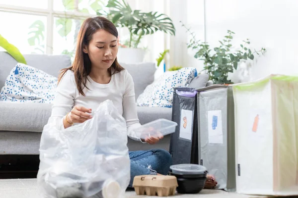 亚洲年轻女性坐在家里分离纸张和塑料废物 垃圾分类供回收利用 减少全球变暖 环境保护的概念 — 图库照片