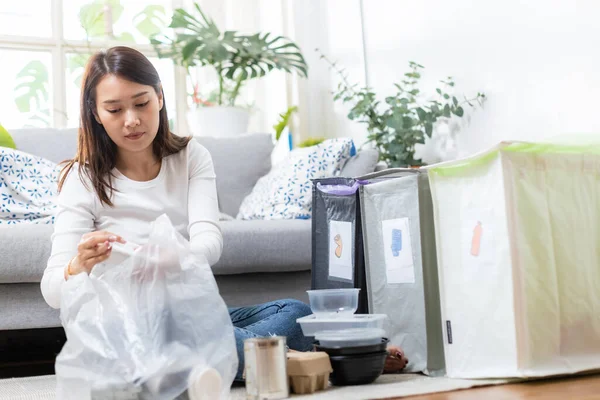 家庭で紙とプラスチックの廃棄物を分離座っているアジアの若い女性 リサイクルのためのゴミ分別 地球温暖化の減少 環境保護の概念は — ストック写真