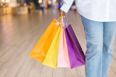 Moda alışverişi. Kadınlar alışveriş çantalarını renkli alışveriş merkezlerinde tutarlar. Kadın gevşeme alışverişi.