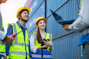 Mühendis, teknisyen, ustabaşı ve ortak kargo konteynır bölgesinde kaskı takıyor, işçi başarısı, konteynır geçmişi.