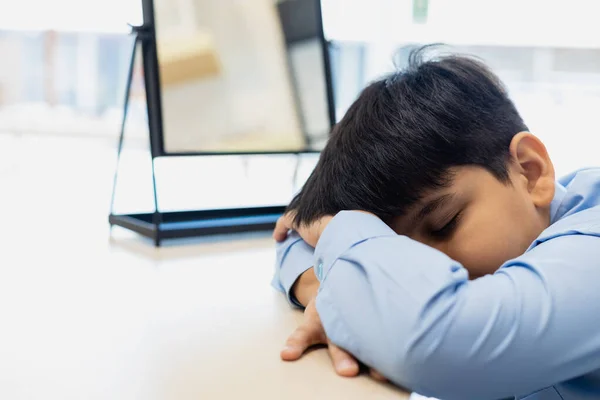 小孩在课桌上睡着了 小学生教育课在课桌边学习小学 小男孩学习后疲倦的睡了 — 图库照片