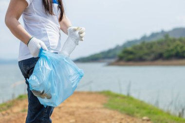 Mavi çöp torbasını kapat. Çöp torbası tutan, çevresel işbirliği yapan, dünyayı kurtaran, küresel ısınmayı azaltan, doğal cazibelerdeki temiz plastik torba atığı olan kadın gönüllüler..