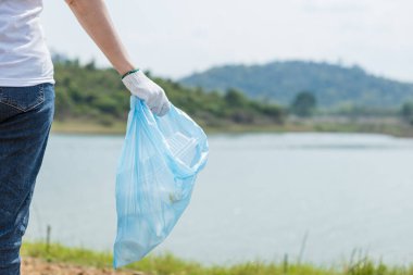 Mavi çöp torbasını kapat. Çöp torbası tutan, çevresel işbirliği yapan, dünyayı kurtaran, küresel ısınmayı azaltan, doğal cazibelerdeki temiz plastik torba atığı olan kadın gönüllüler..