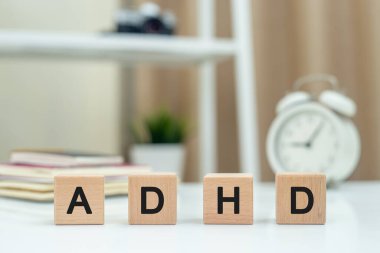 Beyaz masadaki tahta küp bloktaki ADHD 'nin kısaltması. Dikkat eksikliği Hiperaktivite Bozukluğu. Dikkat eksikliği konsepti. Hiperaktiviteyle sonuçlanan psikolojik bozukluk. hareket denetimi eksikliği.