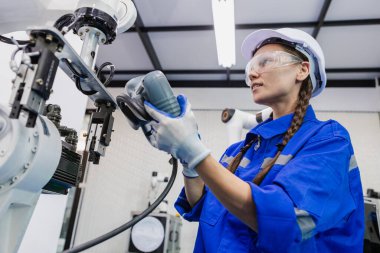 female technician engineer using remote control automation robotics at industrial modern factory. woman working at factory innovation automation robot.