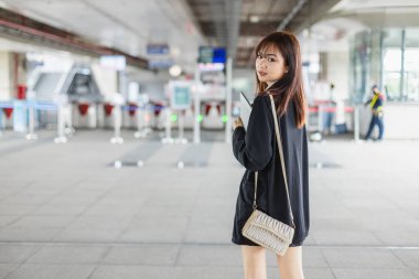 Mutlu bir gülümseme genç Asyalı kadınlar trende toplu taşımada duruyorlar. Demiryolunda güzel bir iş kadını yolcu seyahati. Sabah işe gidip gelen bir kadın..