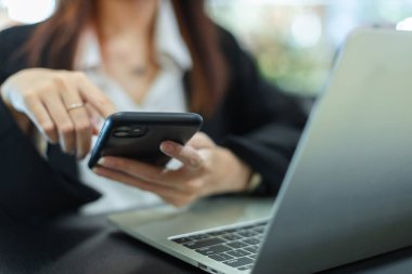 Cep telefonunu kapat. Asyalı çekici kadın işi akıllı telefon oturma ofisi kullanıyor. Mesaj tasarımı için boşluk. İş kadını cep telefonuyla çalışıyor.