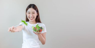 Sebze yiyen mutlu bir kadın. Kadın ve sağlıklı beslenme düzeni. Kilo vermek istiyorum. Sağlıklı beslenme. Sebze salatası menüsünü seç. Faydalı yiyeceklerle dolu. Boşluğu kopyala.