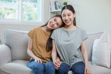Mutlu lezbiyen kız arkadaşlar el ele oturuyor. Asyalı çift. Genç kadın ilişkisi. LGBTQ aşığı lezbiyen.