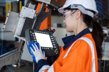 Uzaktan kumandalı, beyaz ekranlı otomasyon robotları. Robot kol sürücüsünün fotoğrafını ya da videosunu koymak için boş alan. Fabrika yenileme otomasyonunda çalışan bir kadın. Beyaz alanı düzenle.