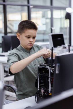 Elektronik sınıftaki çocuk. Çocuk eğitimi elektronik yapay zeka sınıfı ve ekran STEAM dijital. Gelecekteki yapay zekalar için elektronik öğrenme teknolojisi. Elektrik sistemi eğitimi. BTMM eğitim kavramı.