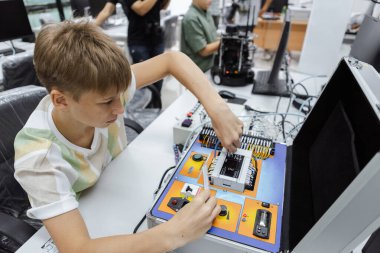 Öğrenci çocuk elektrikli aletleri öğreniyor. Eğitim sınıfın masasında, Robotik öğrenme yeniliği. Elektrik sistemi eğitimi. BTMM eğitim kavramı.