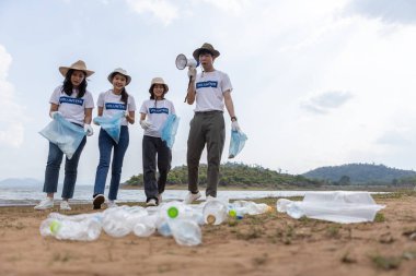 Çöp torbası taşıyan bir grup gönüllü. Turistik yerlerdeki plastik çöpleri temizleyin. Doğadaki koruma ve bakım temizliği. Dünyayı temiz tutmak için davetiye.