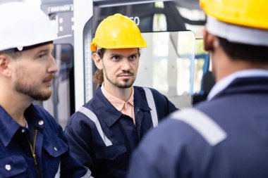 Mühendisler fabrika atölyesinde kask takarlar. Profesyonel teknisyen anlaşma planı yapım, kontrol grubu robotik kol otomasyon yazılımı.