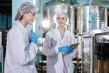 Kadın işçi, temiz içme suyunu filtreleme sürecini kontrol ediyor. Şişelere su doldurma işleminden önce yönetim sistemi. Fabrikanın su üretim hattı.