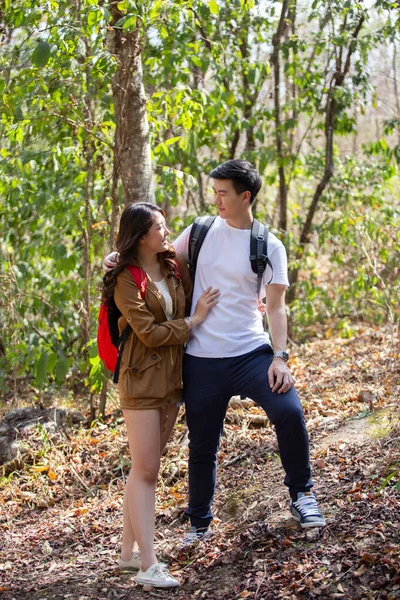 Happy asian couple take care adventure travel trip backpack hiking. Male and female walking way forest path trip nature vacation.