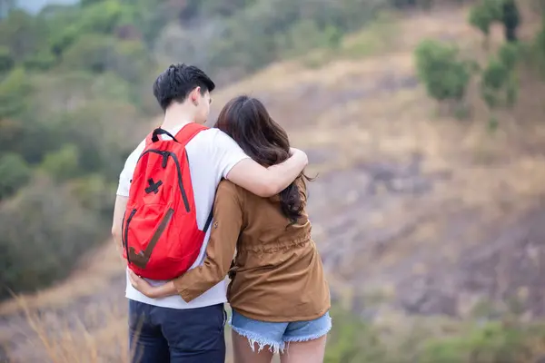 Happy asian couple take care standing on mountain adventure travel trip backpack hiking. Male and female walking way forest path trip nature vacation.
