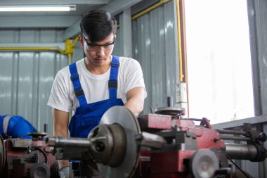 Üniforma giyen teknisyen güvenlikli çalışma makinesi fabrika endüstrisinde metal fren öğütücüsü, işçi üretim endüstrisi konsepti.