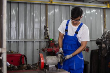 Mühendislik işçisi fabrika endüstrisinde metal fren öğütücüsü kullanıyor. İşçi endüstrisi konsepti..