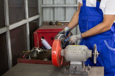 Mühendislik işçisi fabrika endüstrisinde metal parlatma disk öğütücüsü kullanıyor. İşçi üretim endüstrisi konsepti. ekipman, motor, otomotiv.