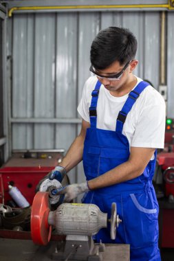 Mühendislik işçisi fabrika endüstrisinde metal parlatma disk öğütücüsü kullanıyor. İşçi üretim endüstrisi konsepti. ekipman, motor, otomotiv.