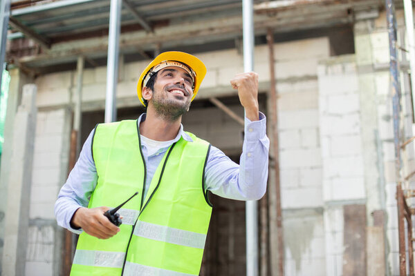 Строитель. счастливый человек инженер носить форму стоя на строительной площадке. Рабочие контролируют строительную инспекцию здания.