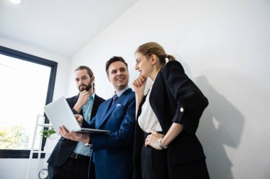 Bir grup iş adamı çalışmak için masadaki bilgisayarı kullanarak beyin fırtınası yapıyor. Örgütteki etkili insanlar fikirlerini işlerine danışmak için kullanırlar..