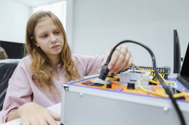 Sınıftaki masada mutlu kız eğitimi elektroniği. Gelecekteki yapay zekalar için elektronik öğrenme teknolojisi. Sistem becerisi eğitimi. BTMM eğitim kavramı.