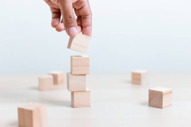 Başarı kavramı. Elele tutuşmak ve tahta blok kübü istiflemek iş büyümesinin basamağı..