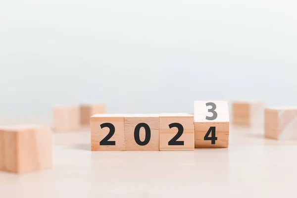 木製のテーブルに 2023 2024 に番号を変更する木製のブロックの立方体 新年2023 2024コンセプト ロイヤリティフリーのストック写真