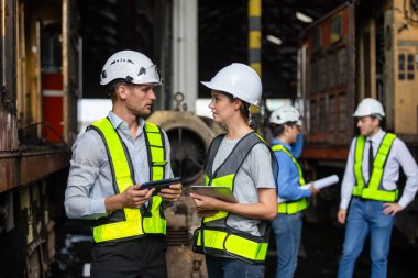 Demiryolu teknisyeni mühendisi bakım merkezinde dizel motor tamir projesini inceleyin. Teknisyen proje planlamasını tartıştı Araç ve demiryolu sistemlerini kontrol etti.