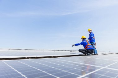 Teknisyenler, bir sanayi fabrikasının çatısına güneş paneli standartları kurup denetliyorlar. Doğadan elde edilen elektrik enerjisi güneş ışığı temiz yenilenebilir enerji.