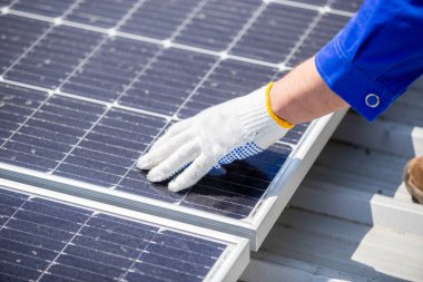 Teknisyenler, bir sanayi fabrikasının çatısına güneş paneli standartları kurup denetliyorlar. Doğadan elde edilen elektrik enerjisi güneş ışığı temiz yenilenebilir enerji.