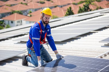 Teknisyenler, bir sanayi fabrikasının çatısına güneş paneli standartları kurup denetliyorlar. Doğadan elde edilen elektrik enerjisi güneş ışığı temiz yenilenebilir enerji.