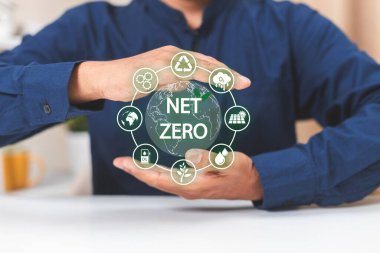 İklim Doğal Çevre Merkezi Konsepti. Net sıfır simgelerini elinde tutan bir iş adamı. yenilik ısınma 2050 alternatif. Karbon dengeleyici Ana işlem sera ayıklama.
