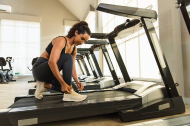 Spor ayakkabı bağlama, spor ayakkabısı spor salonunda koşu bandı egzersizi. Sporcu kadın motivasyonu spor koşusu kalorileri yakar.