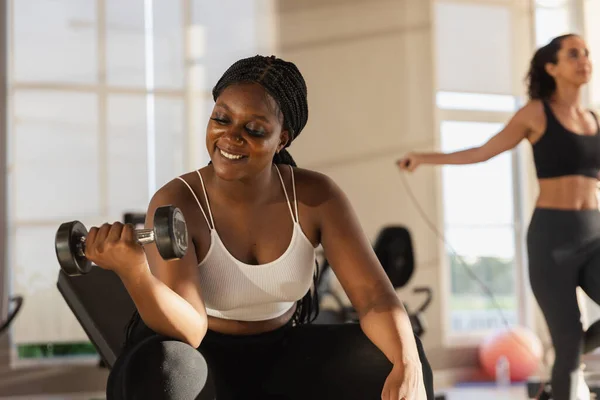Healthy strong female African American plus-size holding dumbbells lifts weights exercise in gym. sport training weights fitness, Exercise to lose weight, take care of health.