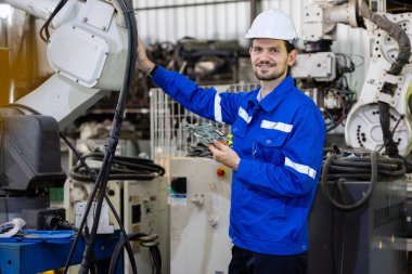 Endüstriyel robot kolunun devre ana kartının yerini alan teknisyen donanımı. Robot devre onarım işçisi. İnsan bakım işçisi robot mekanik servisi.