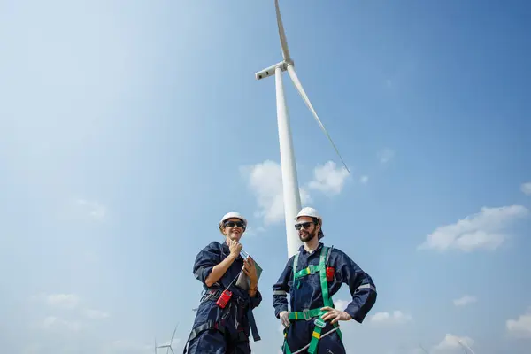 Team engineer wind turbine worker safety uniform survey discuss operational planning windmill field clean energy. Alternative technology protect environment reduce global warming problems.