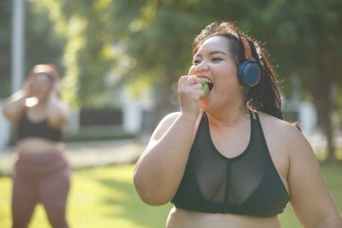 Asyalı kadın aşırı kilolu spor giyim ve kulaklık takarak elma aerobik egzersizi yapıyor. Kadınlar artı aerobik dans yaşam tarzı. Sağlıklı kavram.