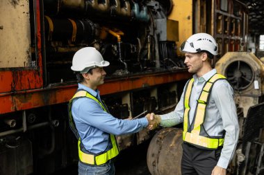 Team railway engineer Inspect repair project train diesel engine in maintenance center shake hand. Technician discuss planning checking vehicle and railroad systems. clipart