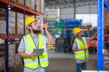 Depoda profesyonel erkek telsiz kontrol işçisi var. Denetmen ithalat-ihracat taşımacılığı, lojistik işletme fabrikası konsepti.