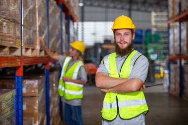 Erkek profesyonel işçi depoda kollarını kavuşturdu. Denetmen ithalat-ihracat taşımacılığı, lojistik işletme fabrikası konsepti.