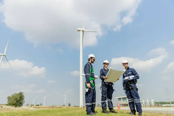Team engineer wind turbine worker safety uniform survey discuss operational planning windmill field clean energy. Alternative technology protect environment reduce global warming problems.