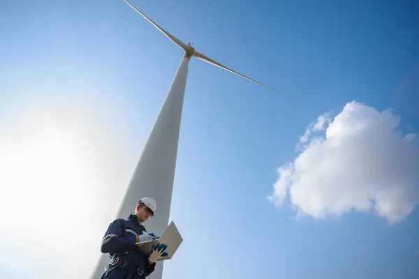 man engineer wearing safety uniform using laptop plan about renewable energy at station energy power wind. technology protect environment reduce global warming problems.