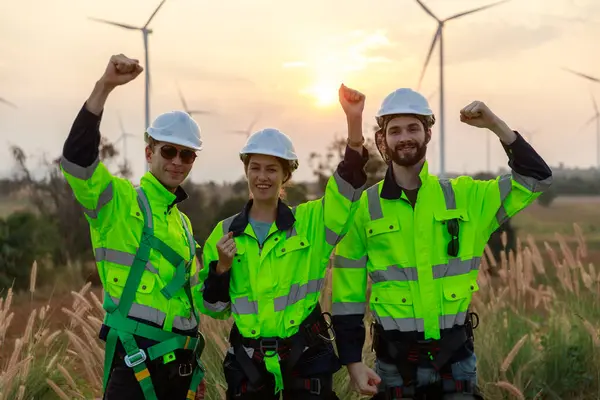 Successful teamwork engineer wind turbine worker safety uniform survey operational planning windmill field clean energy. Alternative technology protect environment reduce global warming problems.
